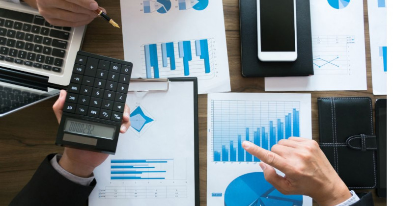 Gráficos financieros sobre una mesa, debate entre asesores