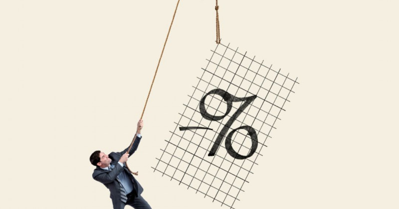 Un hombre levanta una cifra porcentual con una polea