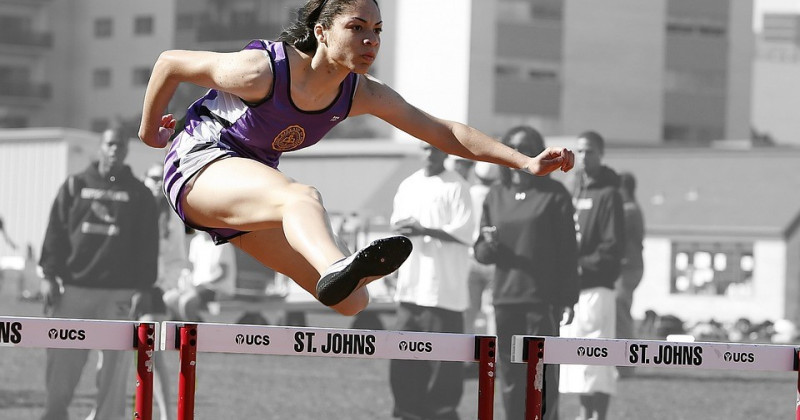 Una corredora salta un obstáculo